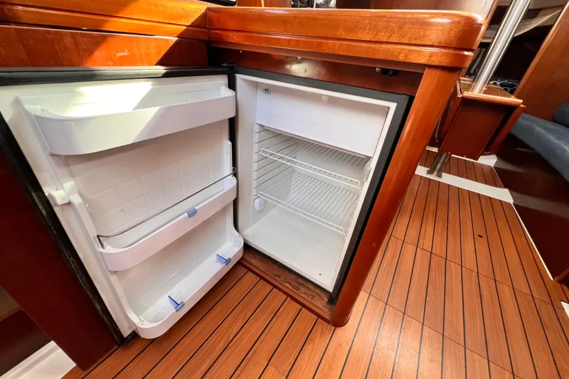 Slide: The Image of Open fridge inside 2005 Beneteau 343 yacht, featuring wooden interior and flooring. - 13