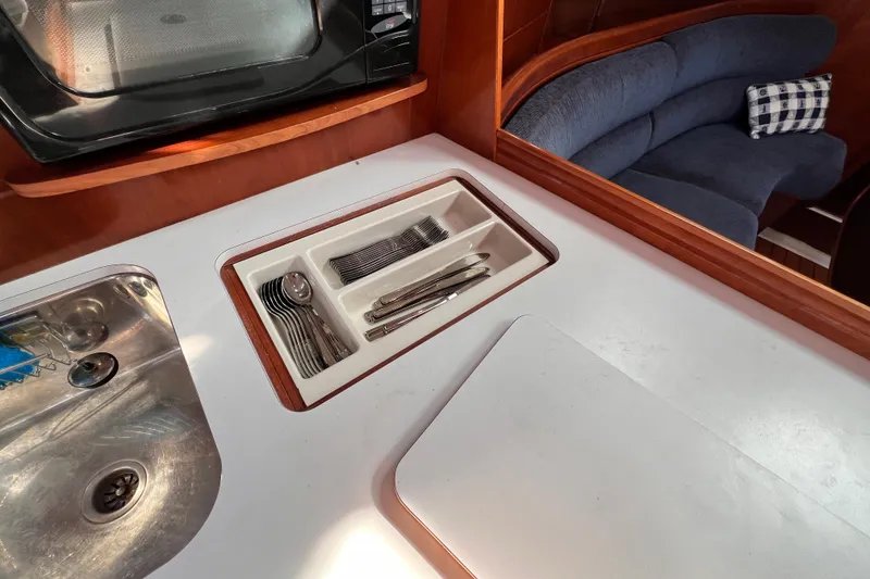 Slide: The Image of Galley of 2005 Beneteau 343 sailboat with sink, cutlery drawer, and seating area. - 14
