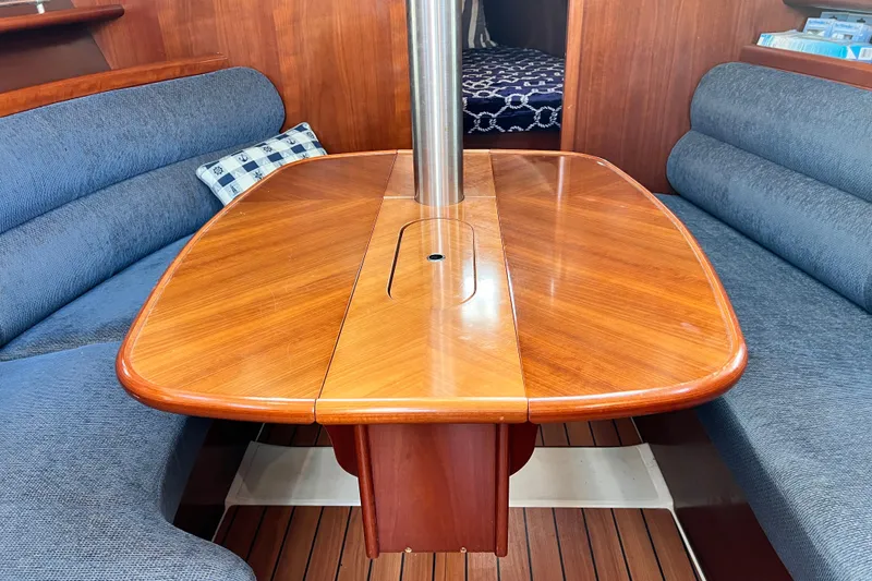 Slide: The Image of Interior of 2005 Beneteau 343 sailboat with wooden table and blue seating. - 18
