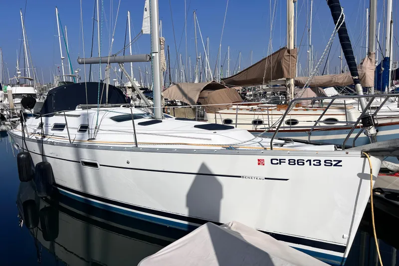 Slide: The Image of 2005 Beneteau 343 sailboat docked in a marina, surrounded by other boats. - 2