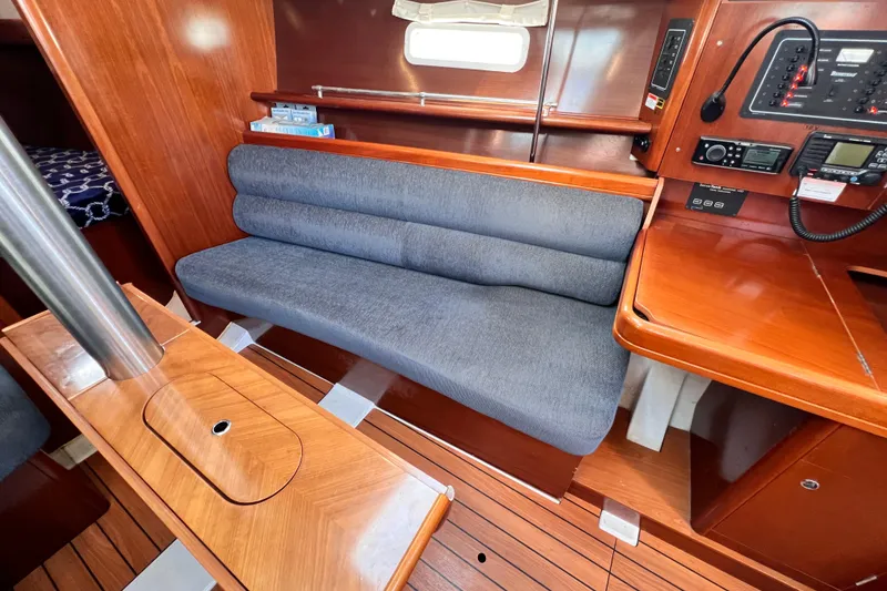 Slide: The Image of Interior of 2005 Beneteau 343 sailboat with wooden finish and blue cushioned seating. - 20