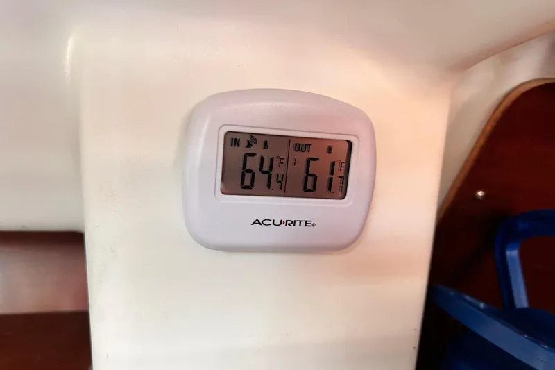 Slide: The Image of AcuRite thermometer displaying indoor 64°F and outdoor 61°F on Beneteau 343, 2005 model. - 23