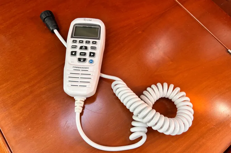 Slide: The Image of Icom CommandMic on Beneteau 343 yacht, 2005 model, resting on wooden surface. - 25