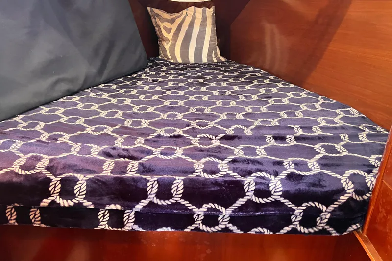 Slide: The Image of Cozy cabin bed in 2005 Beneteau 343 sailboat with nautical-themed bedding. - 30