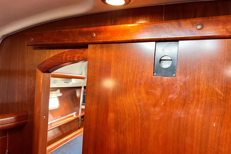 Slide: The Image of Interior of 2005 Beneteau 343 yacht with wooden sliding door and cozy cabin view. - 33