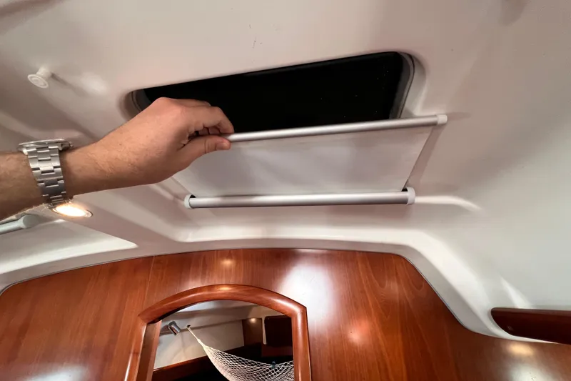 Slide: The Image of Hand adjusting hatch cover inside 2005 Beneteau 343 sailboat cabin. - 35