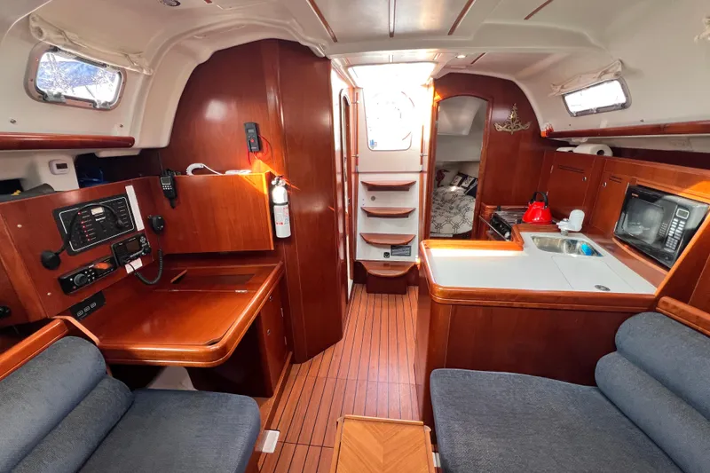 Slide: The Image of Interior of 2005 Beneteau 343 sailboat with wood finish, kitchenette, and seating area. - 36
