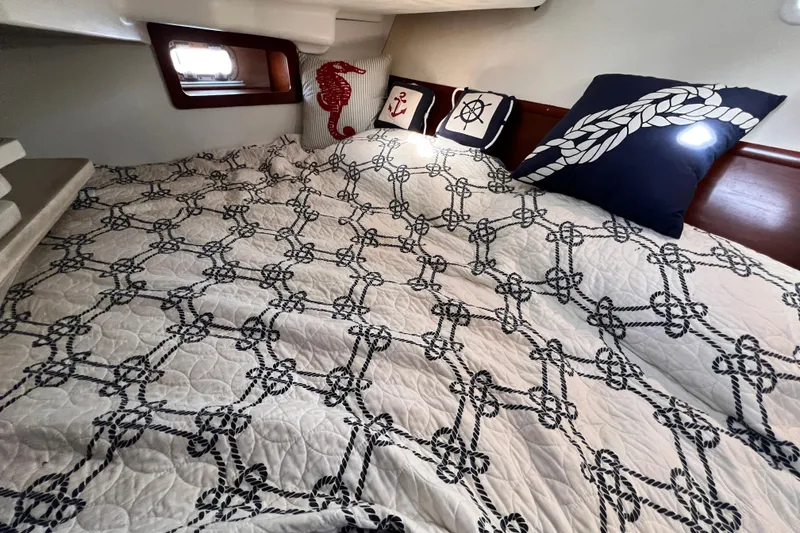 Slide: The Image of Cozy cabin interior of 2005 Beneteau 343 with nautical-themed bedding and pillows. - 39
