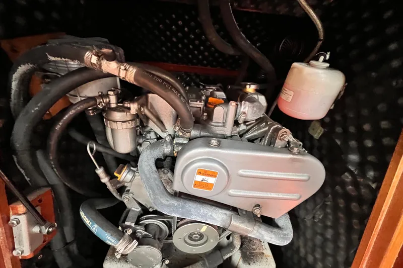 Slide: The Image of Engine compartment of a 2005 Beneteau 343 sailboat, showcasing mechanical components and hoses. - 44