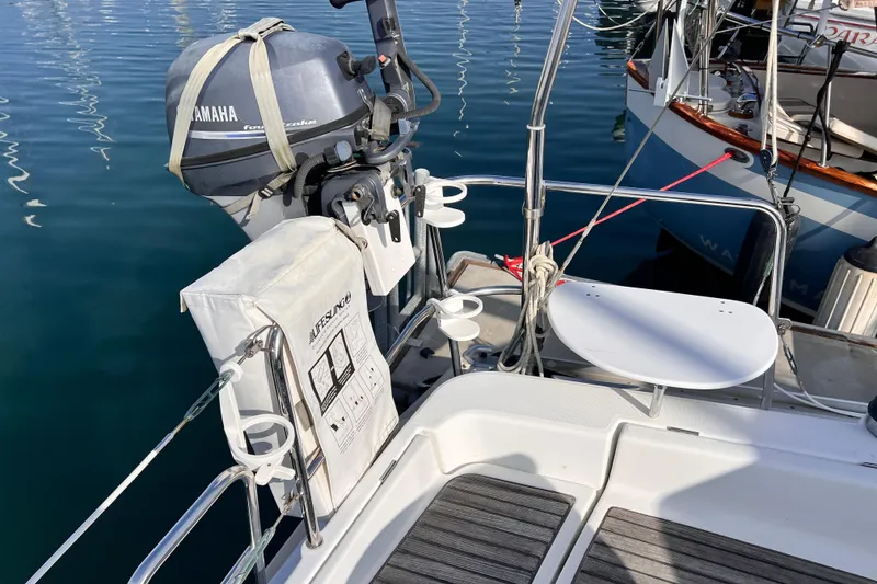 Slide: The Image of Beneteau 343 sailboat stern with Yamaha outboard motor, docked in calm waters. - 48
