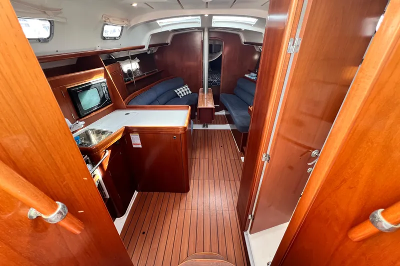Slide: The Image of Interior of 2005 Beneteau 343 sailboat with wood finish and cozy seating area. - 5