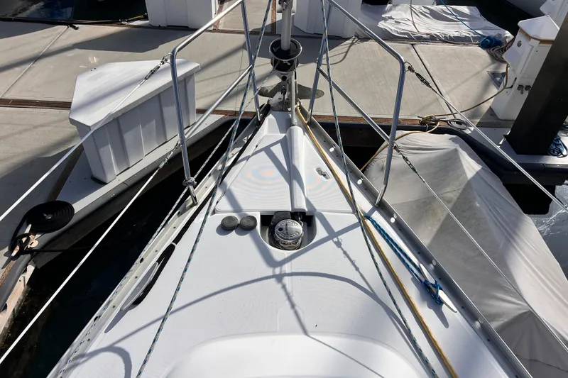Slide: The Image of Bow of 2005 Beneteau 343 sailboat docked at marina, featuring deck details and railing. - 52