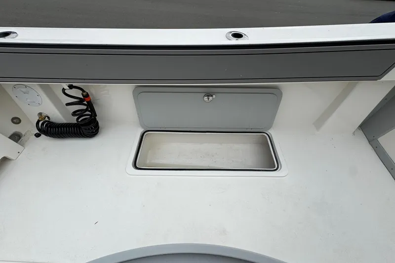 Slide: The Image of 2026 Defiance Admiral 220 EX boat deck with storage compartment and coiled hose. - 18