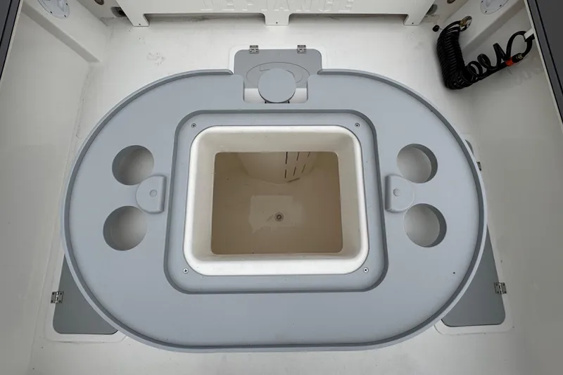 Slide: The Image of 2026 Defiance Admiral 220 EX boat storage compartment with cup holders and central bin. - 20