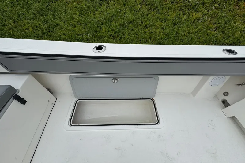 Slide: The Image of 2026 Defiance Admiral 220 EX boat interior with storage compartment and rod holders. - 21