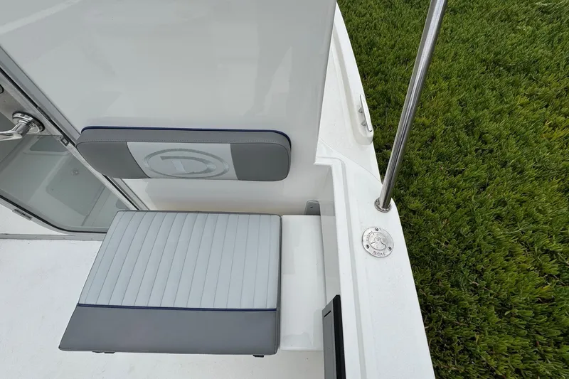 Slide: The Image of 2026 Defiance Admiral 220 EX boat seat and deck detail with lush green background. - 25