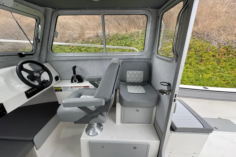 Slide: The Image of Interior of 2026 Defiance Admiral 220 EX boat, featuring steering wheel and seating. - 29