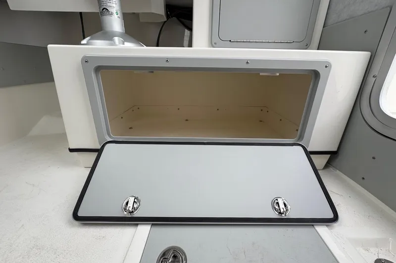 Slide: The Image of Open storage compartment in 2026 Defiance Admiral 220 EX boat interior. - 32