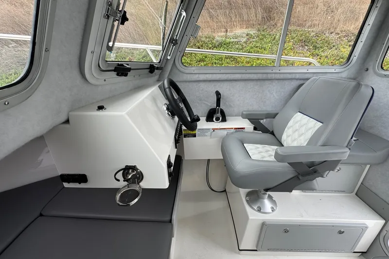 Slide: The Image of Interior of 2026 Defiance Admiral 220 EX boat with steering console and cushioned captain's chair. - 40