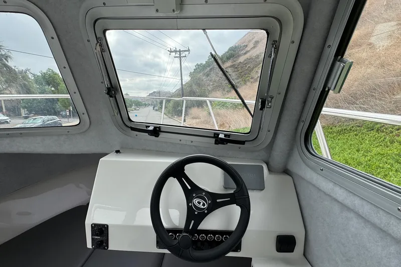 Slide: The Image of Interior view of 2026 Defiance Admiral 220 EX boat cockpit with steering wheel and windows. - 46