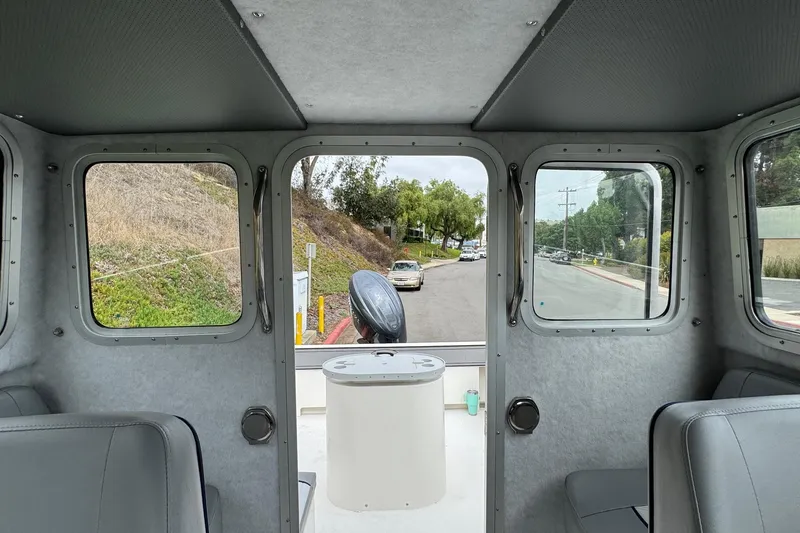 Slide: The Image of Interior view of 2026 Defiance Admiral 220 EX boat, showcasing windows and seating. - 57