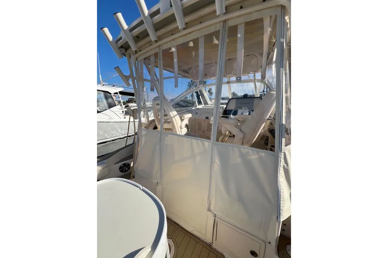 Slide: The Image of 2021 Grady-White Marlin 300 boat cockpit with protective enclosure and steering wheel. - 19
