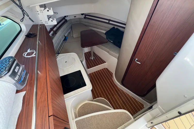 Slide: The Image of 2021 Grady-White Marlin 300 cabin interior with wood accents and seating area. - 9