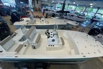 Slide: The Image of 2025 Mako Pro Skiff 19 CC boat displayed in a showroom, featuring spacious seating and modern design. - 71