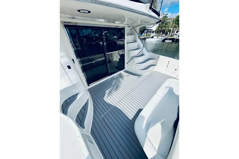 Slide: The Image of 2003 Sea Ray 560 Sedan Bridge yacht deck with sleek seating and waterfront view. - 10