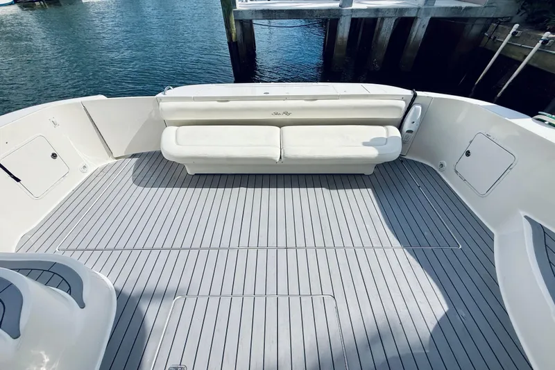 Slide: The Image of 2003 Sea Ray 560 Sedan Bridge yacht deck with white seating and gray flooring. - 11