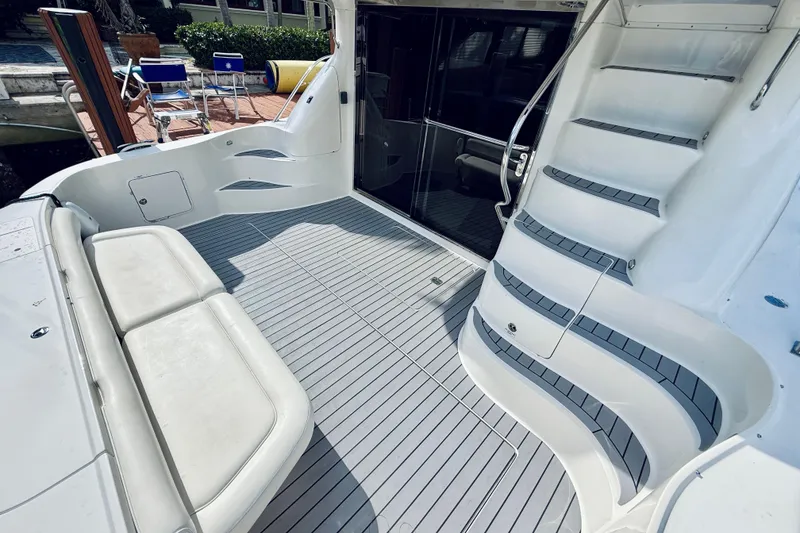 Slide: The Image of 2003 Sea Ray 560 Sedan Bridge yacht deck with seating and stairs. - 12