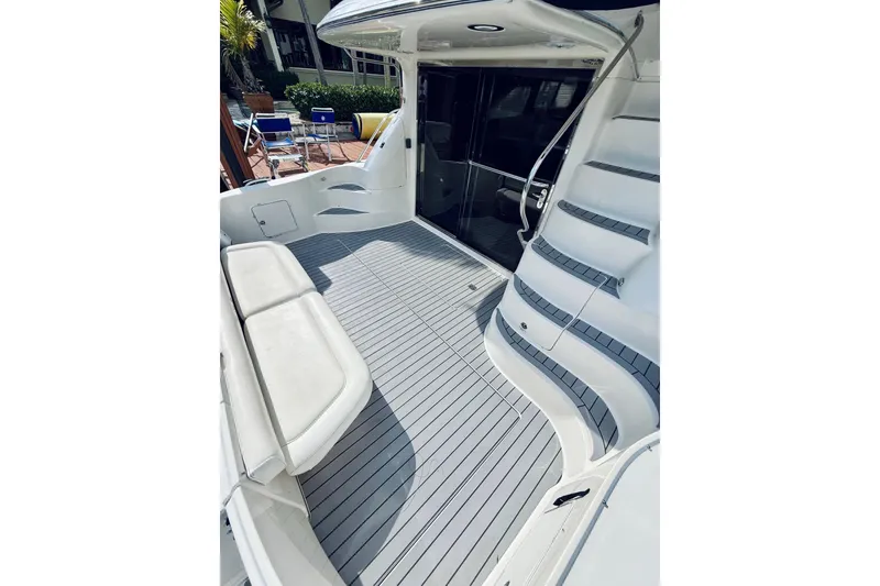 Slide: The Image of 2003 Sea Ray 560 Sedan Bridge yacht deck with seating and stairs. - 13