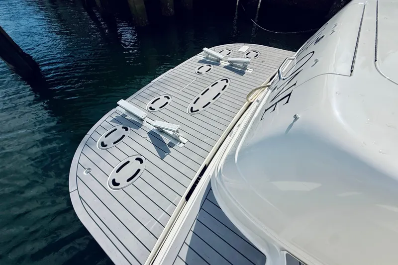 Slide: The Image of 2003 Sea Ray 560 Sedan Bridge swim platform with cleats, docked on calm water. - 15