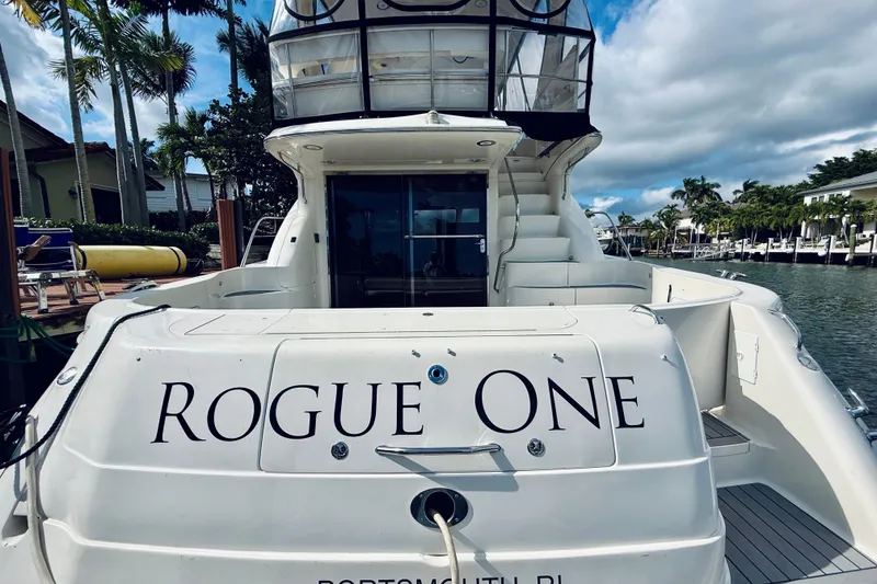 Slide: The Image of 2003 Sea Ray 560 Sedan Bridge yacht named "Rogue One" docked by palm trees. - 18