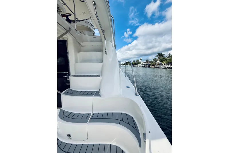 Slide: The Image of 2003 Sea Ray 560 Sedan Bridge yacht with elegant exterior stairs and waterfront view. - 19