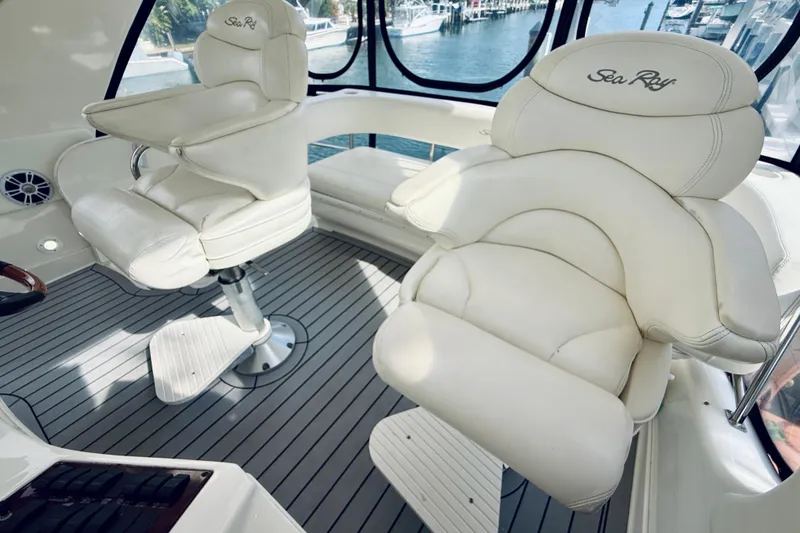 Slide: The Image of Luxurious seating on 2003 Sea Ray 560 Sedan Bridge yacht, featuring plush white captain chairs. - 24