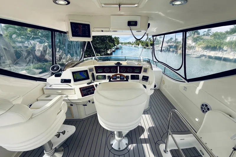 Slide: The Image of 2003 Sea Ray 560 Sedan Bridge helm with modern navigation equipment and waterfront view. - 25