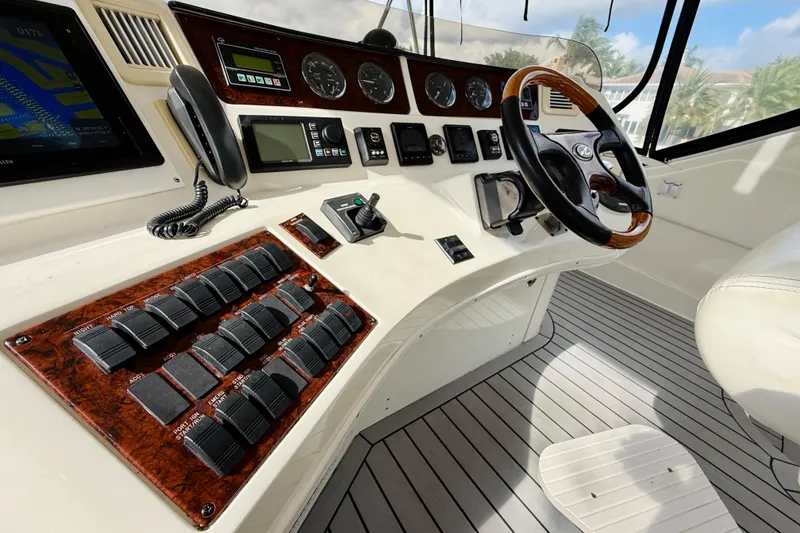 Slide: The Image of 2003 Sea Ray 560 Sedan Bridge helm with controls, gauges, and steering wheel. - 26