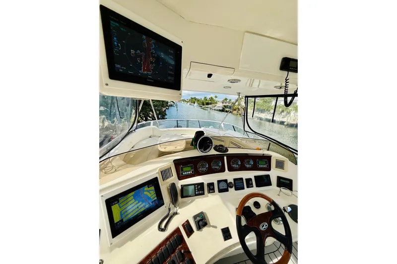 Slide: The Image of 2003 Sea Ray 560 Sedan Bridge helm with navigation screens and steering wheel. - 28