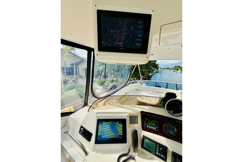 Slide: The Image of 2003 Sea Ray 560 Sedan Bridge helm with navigation screens and river view. - 31
