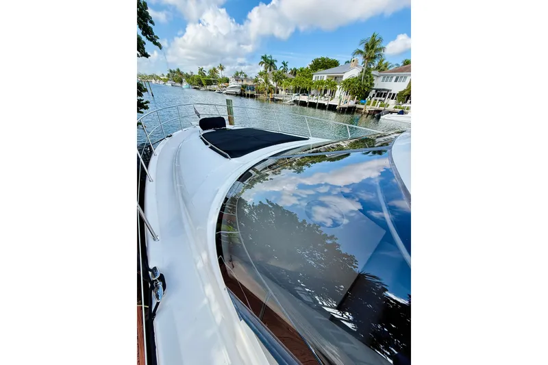 Slide: The Image of 2003 Sea Ray 560 Sedan Bridge yacht on a scenic waterfront. - 5