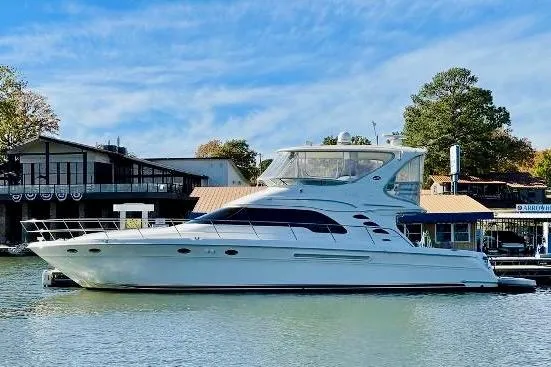 Slide: The Image of 2003 Sea Ray 560 Sedan Bridge yacht docked by waterfront buildings. - 68