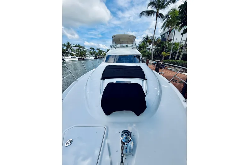 Slide: The Image of 2003 Sea Ray 560 Sedan Bridge yacht docked, featuring sleek design and spacious deck. - 7