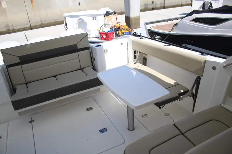 Slide: The Image of 2019 Pursuit DC 365 Dual Console boat interior with seating and table. - 24