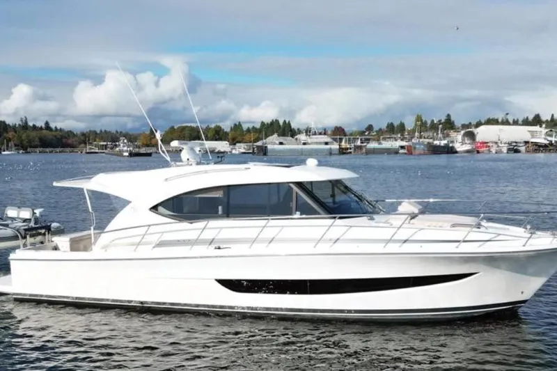 The Image of 2019 Riviera 395 SUV yacht on calm water with scenic background. - 1