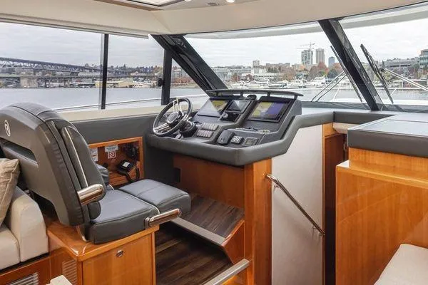 Slide: The Image of 2019 Riviera 395 SUV yacht interior with modern helm and cityscape view. - 10