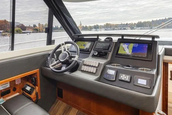 Slide: The Image of 2019 Riviera 395 SUV helm with advanced navigation systems and scenic waterway view. - 11