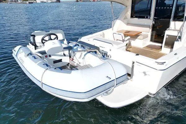 Slide: The Image of 2019 Riviera 395 SUV with attached inflatable boat on water. - 28