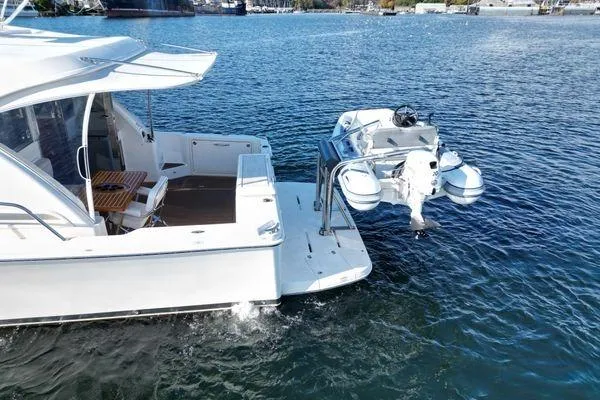 Slide: The Image of 2019 Riviera 395 SUV yacht with attached dinghy on calm water. - 30