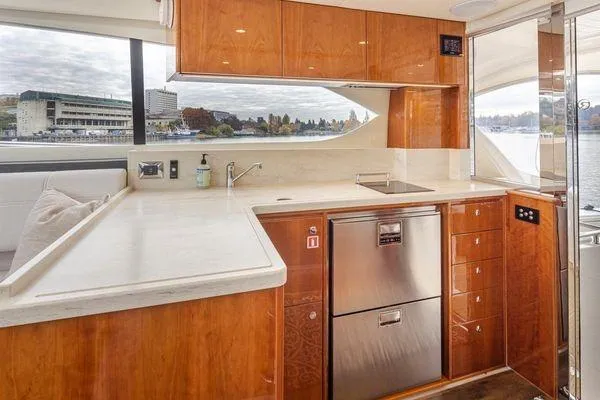 Slide: The Image of Luxurious 2019 Riviera 395 SUV yacht kitchen with modern appliances and elegant wood cabinetry. - 5